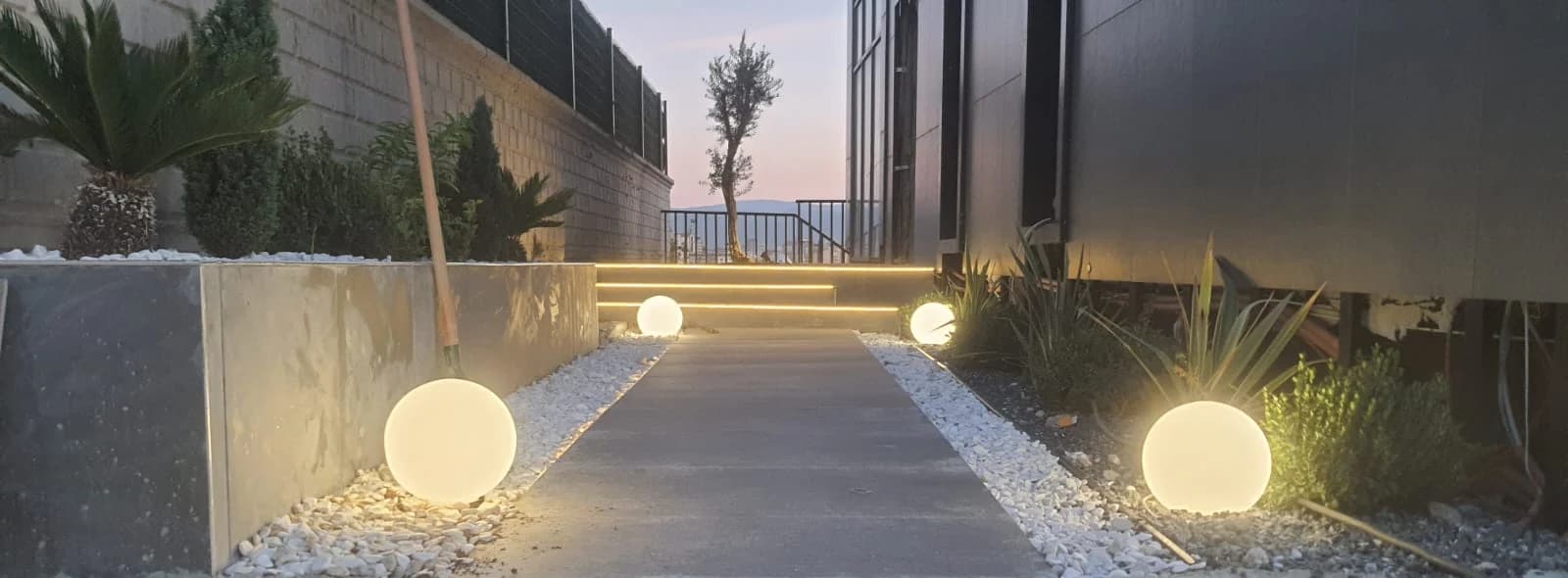 Küre aydınlatmalarla çevrelenmiş peyzaj yürüyüş yolu