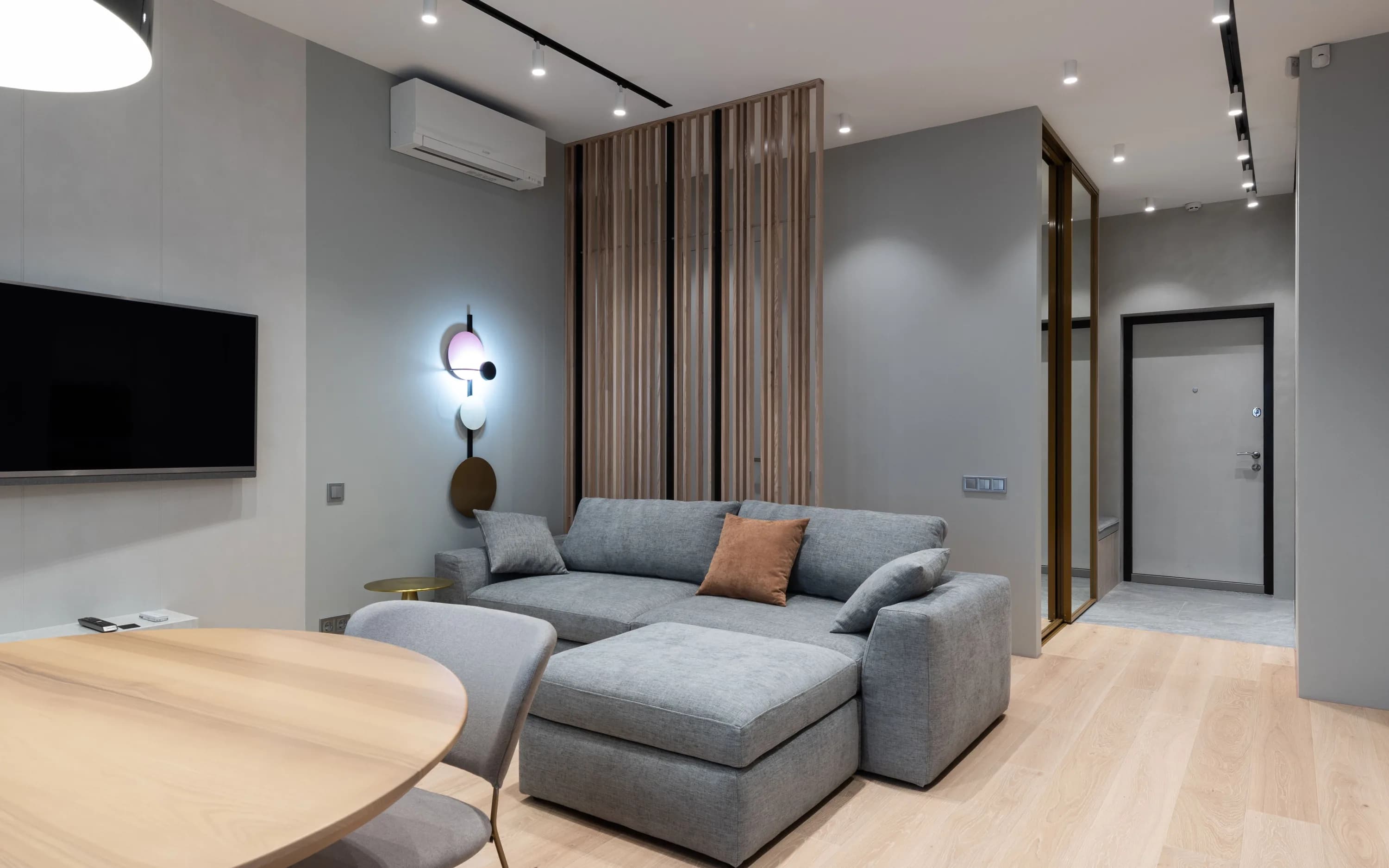 Split klima, televizyon ünitesi ve dengeli oturma düzeni bulunan modern salon